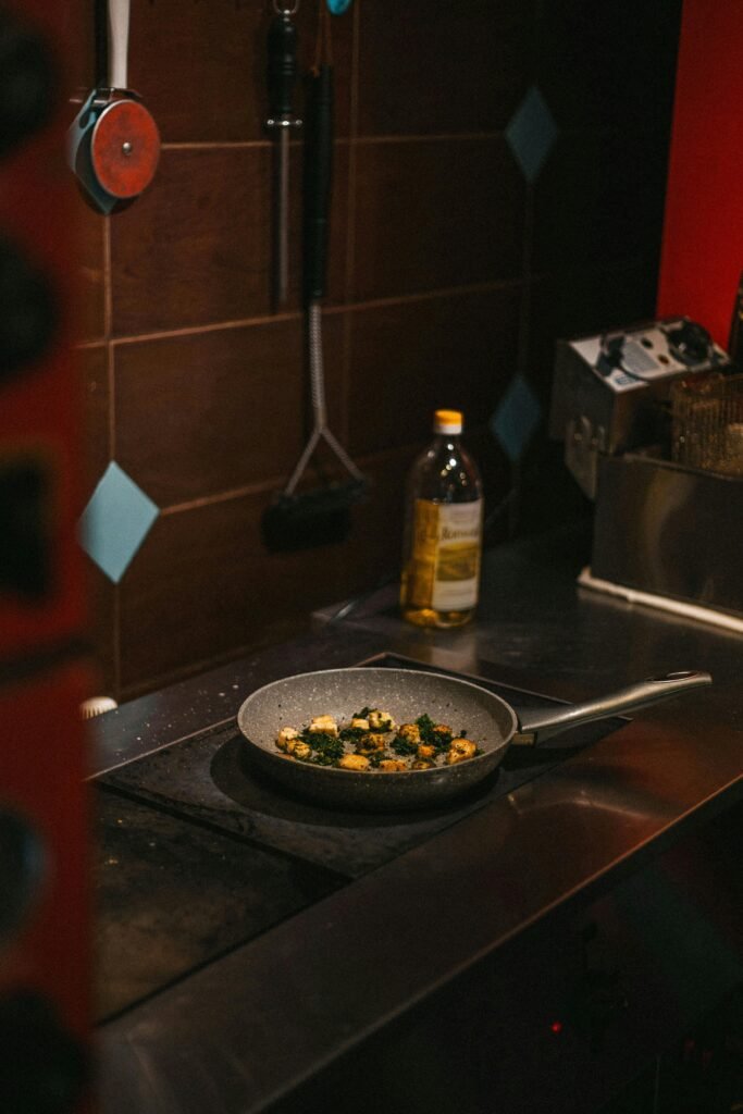 A cozy kitchen scene with vegetables frying in a pan on a stove.